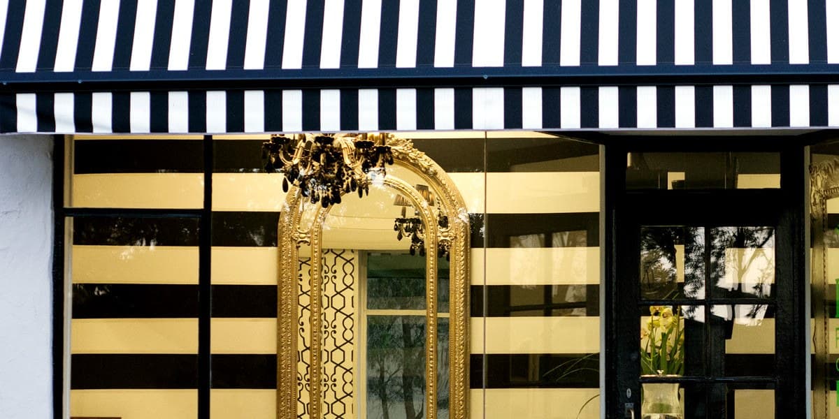 The salon front with its black and cream striped awning